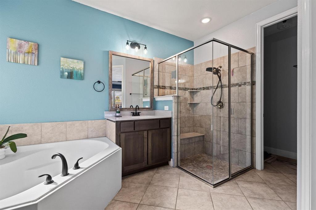 13798 Fernando Road Frisco, TX 75035 - Photo 20 of 39 a bathroom with a granite countertop sink a mirror a bathtub and shower