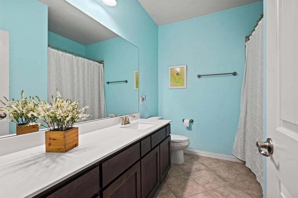13798 Fernando Road Frisco, TX 75035 - Photo 27 of 39 a bathroom with a granite countertop sink a toilet and mirror