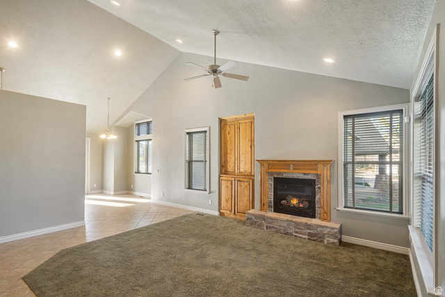 1997 West Cres Drive Mapleton, UT 84664 - Photo 8 of 35 Unfurnished living room with a stone fireplace, ceiling fan, light carpet, recessed lighting, and light tile patterned flooring