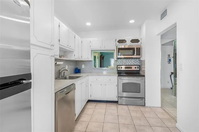 a kitchen with a stove top oven and cabinets