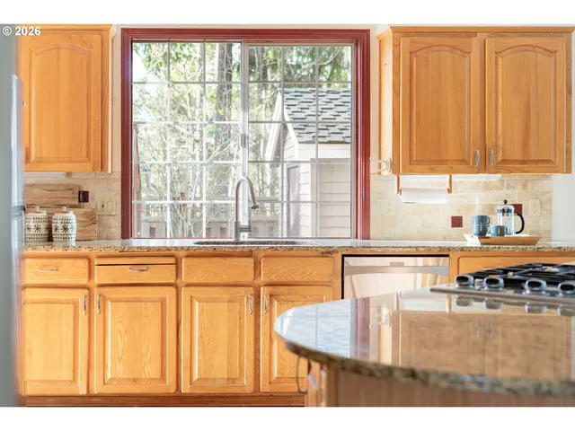 a kitchen with stainless steel appliances granite countertop a sink and a window