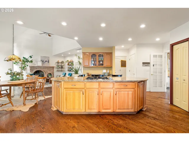 a living room with stainless steel appliances kitchen island granite countertop a refrigerator and a sink