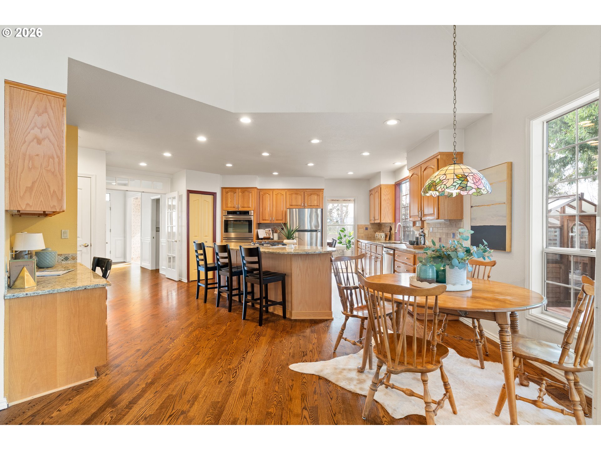 9985 Southwest 141st Avenue Beaverton, OR 97008 - Photo 17 of 47 a dining hall with stainless steel appliances a dining table chairs and a living room view