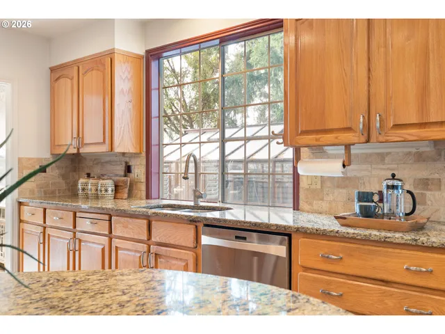 a kitchen with granite countertop a stove a sink and a counter top space