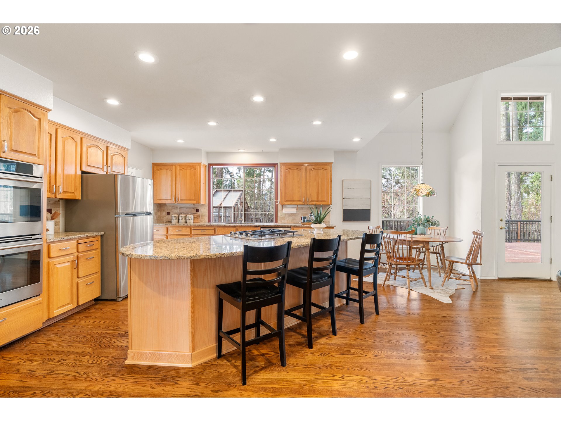 9985 Southwest 141st Avenue Beaverton, OR 97008 - Photo 19 of 47 a dining hall with stainless steel appliances granite countertop a refrigerator a stove a dining table and chairs