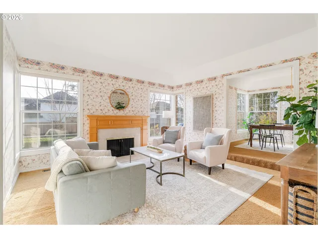 a living room with furniture a fireplace and a floor to ceiling window