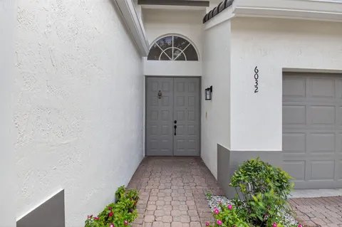a patio with table and chairs and potted plants