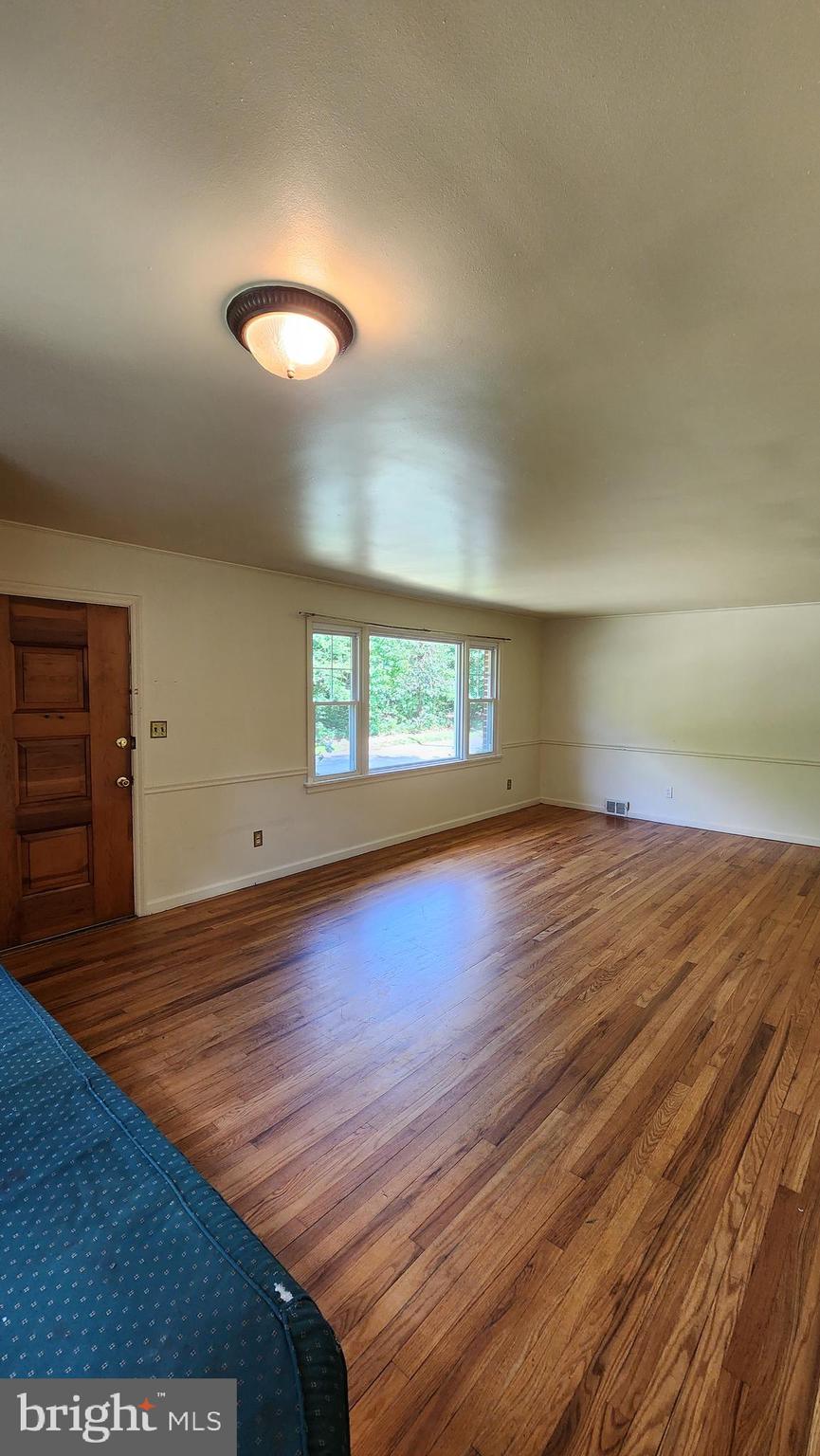 117 Girard Road North Glassboro, NJ 08028 - Photo 3 of 17 an empty room with wooden floor and windows