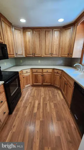 a view of a kitchen with wooden floors and a sink
