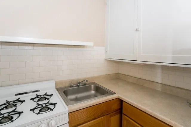 a kitchen with a sink stove and cabinets