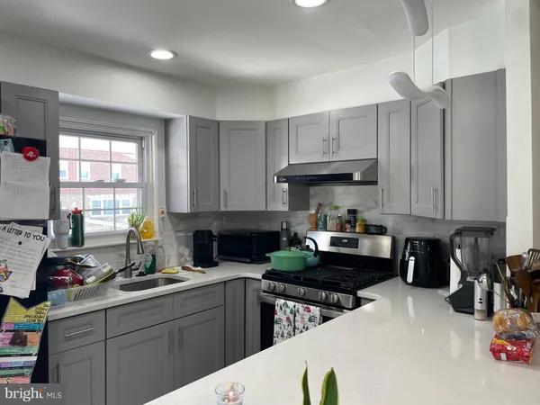 a kitchen with a sink a stove and cabinets