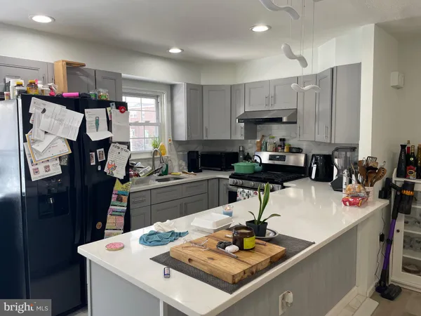 a kitchen with a refrigerator and a stove top oven