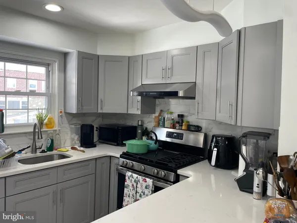 a kitchen with granite countertop a sink stove and cabinets