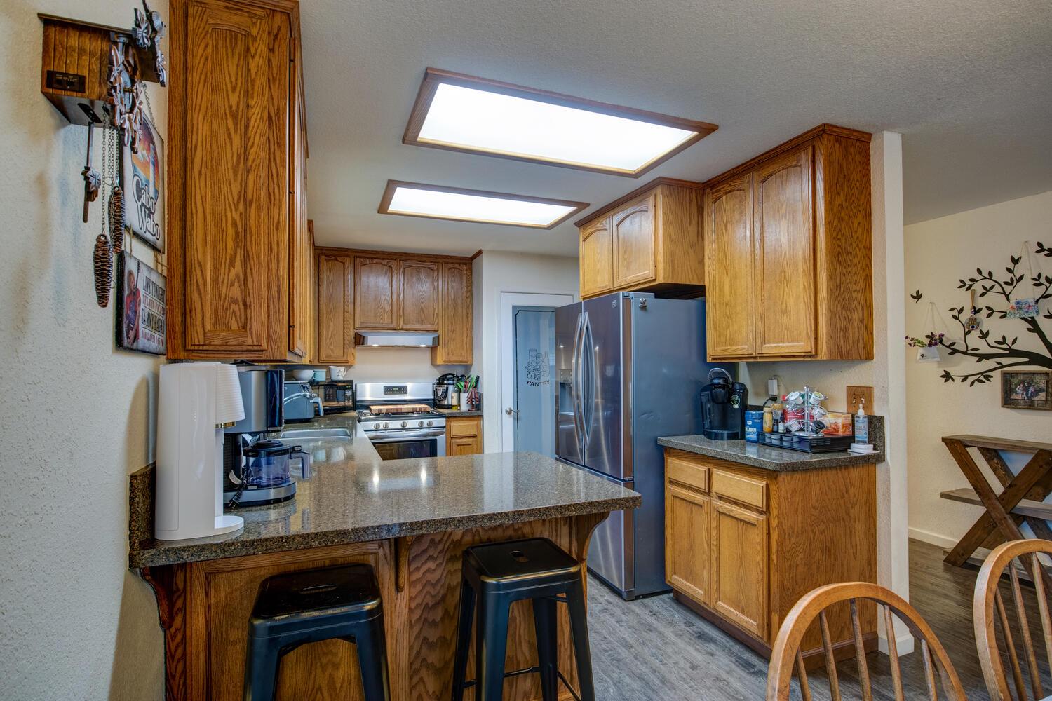 23832 Old Madrone Road Pioneer, CA 95666 - Photo 16 of 48 a kitchen with stainless steel appliances a stove a sink dishwasher and cabinets