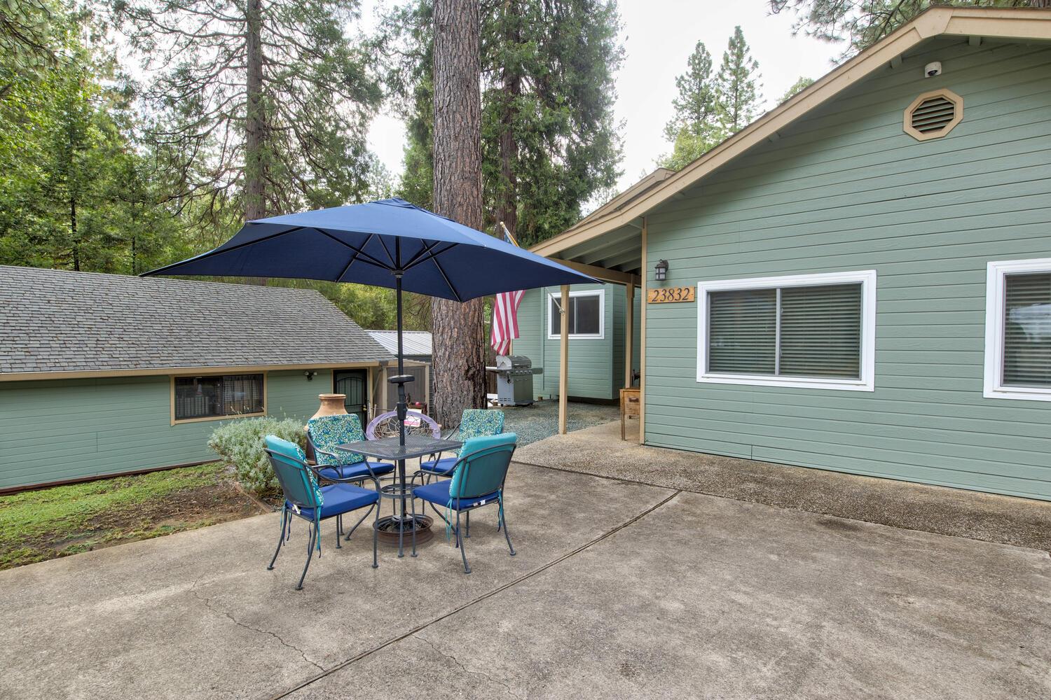 23832 Old Madrone Road Pioneer, CA 95666 - Photo 4 of 48 a patio with a table and chairs under an umbrella