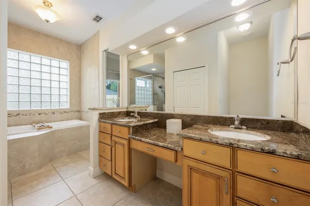 a bathroom with a granite countertop sink and a bathtub