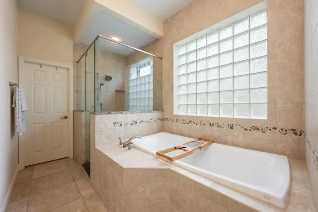 a bathroom with a tub sink and mirror
