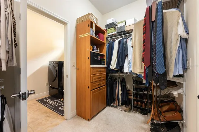 a view of walk in closet with clothes and shoes