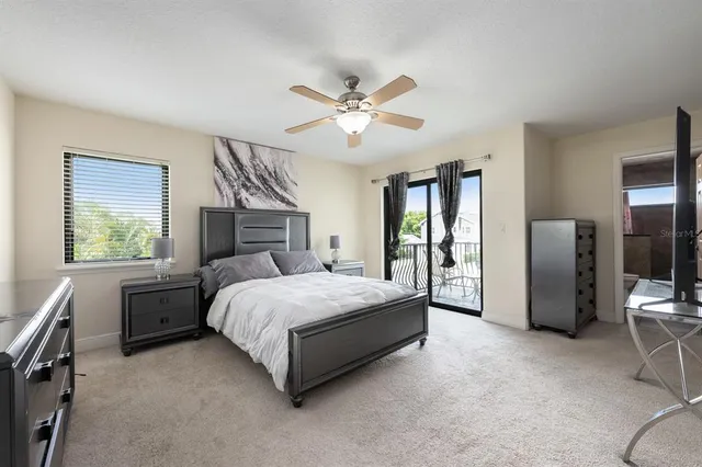 a spacious bedroom with a large bed and a chandelier