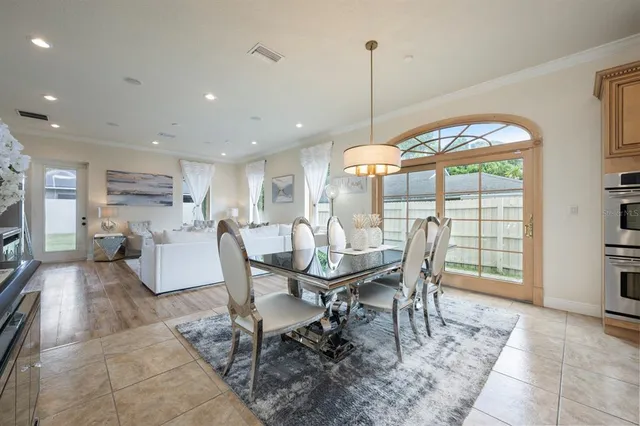 a dining room with furniture a chandelier and wooden floor