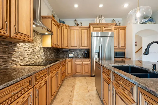 a kitchen with stainless steel appliances granite countertop a sink a stove and a refrigerator