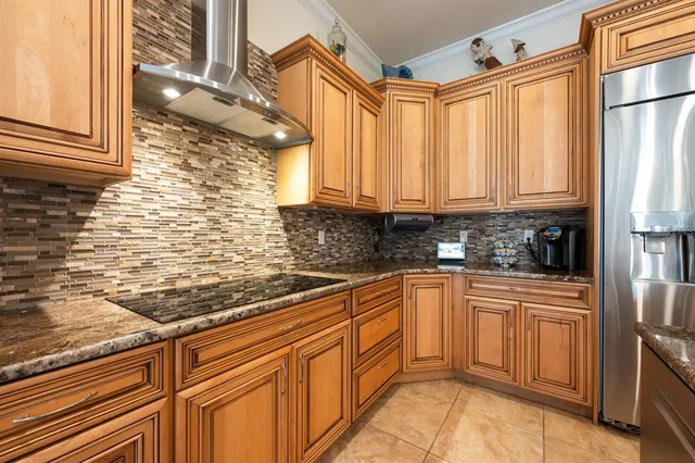 a kitchen with stainless steel appliances granite countertop a refrigerator and a stove