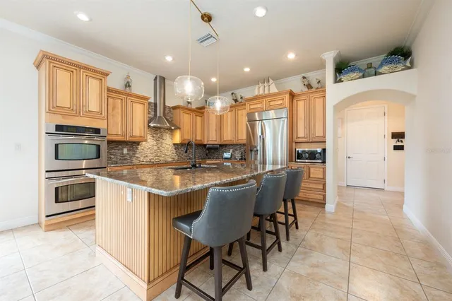 a kitchen with kitchen island granite countertop lots of white cabinets appliances and furniture