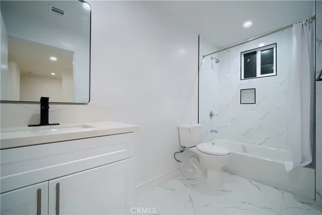 a bathroom with a toilet a sink and shower