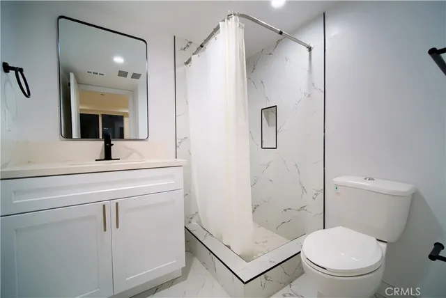 a bathroom with a shower a toilet and sink