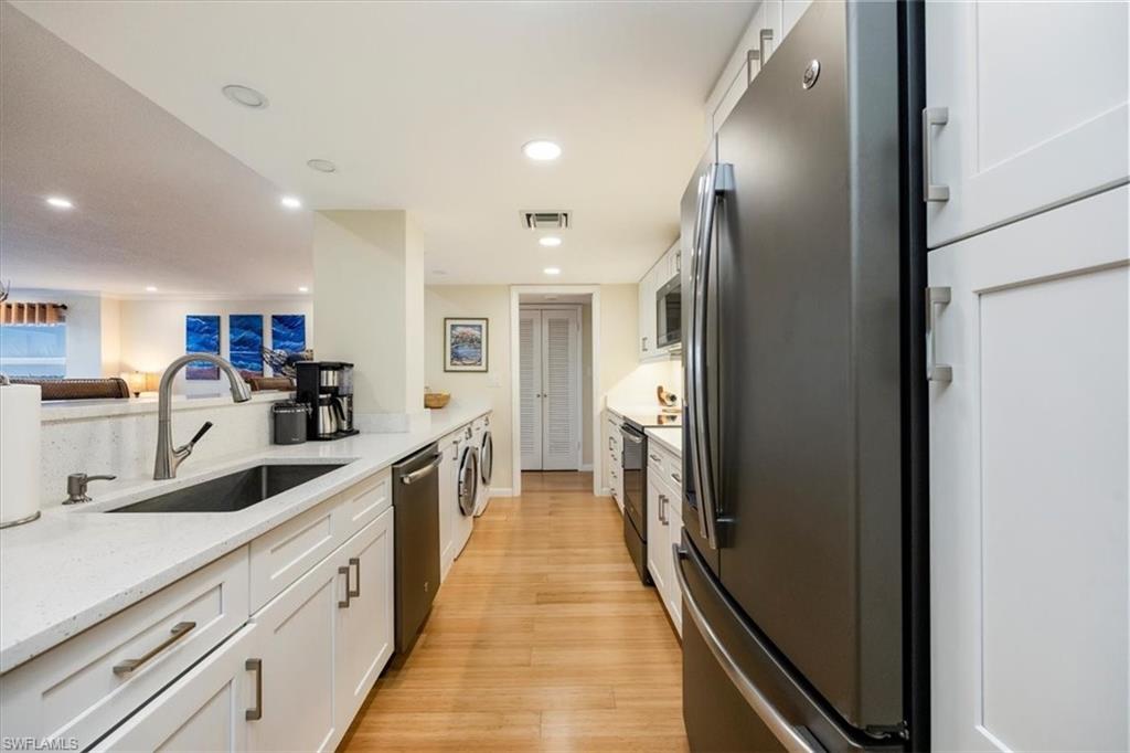 1900 Clifford Street, Unit 301 Fort Myers, FL 33901 - Photo 7 of 35 Kitchen featuring appliances with stainless steel finishes, white cabinetry, light wood-type flooring, recessed lighting, and light stone countertops
