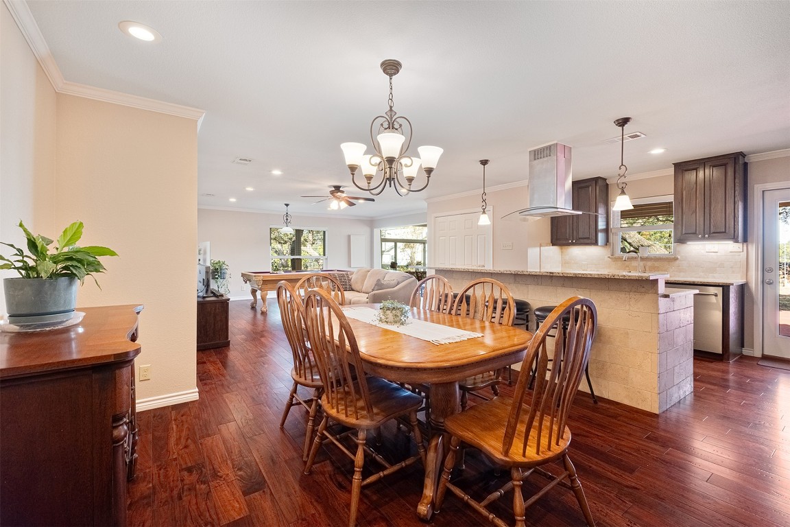 280 Sunset Terrace Cedar Park, TX 78613 - Photo 3 of 38 a dining room with wooden floor a chandelier a wooden table and chairs