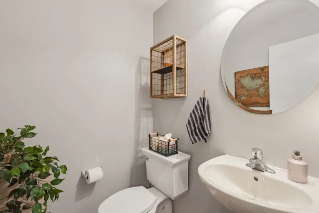 a bathroom with a toilet a sink and mirror