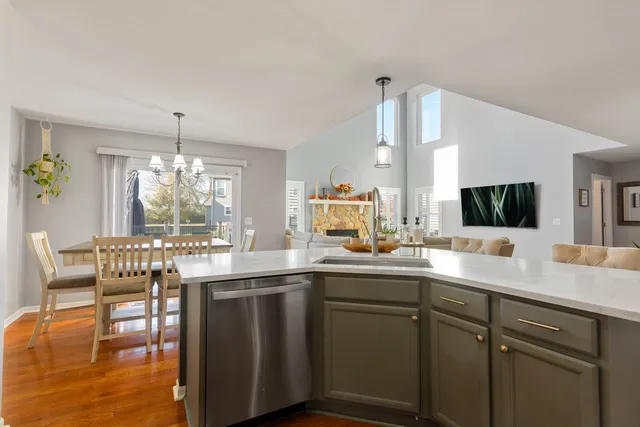 a kitchen with a sink a window and chairs