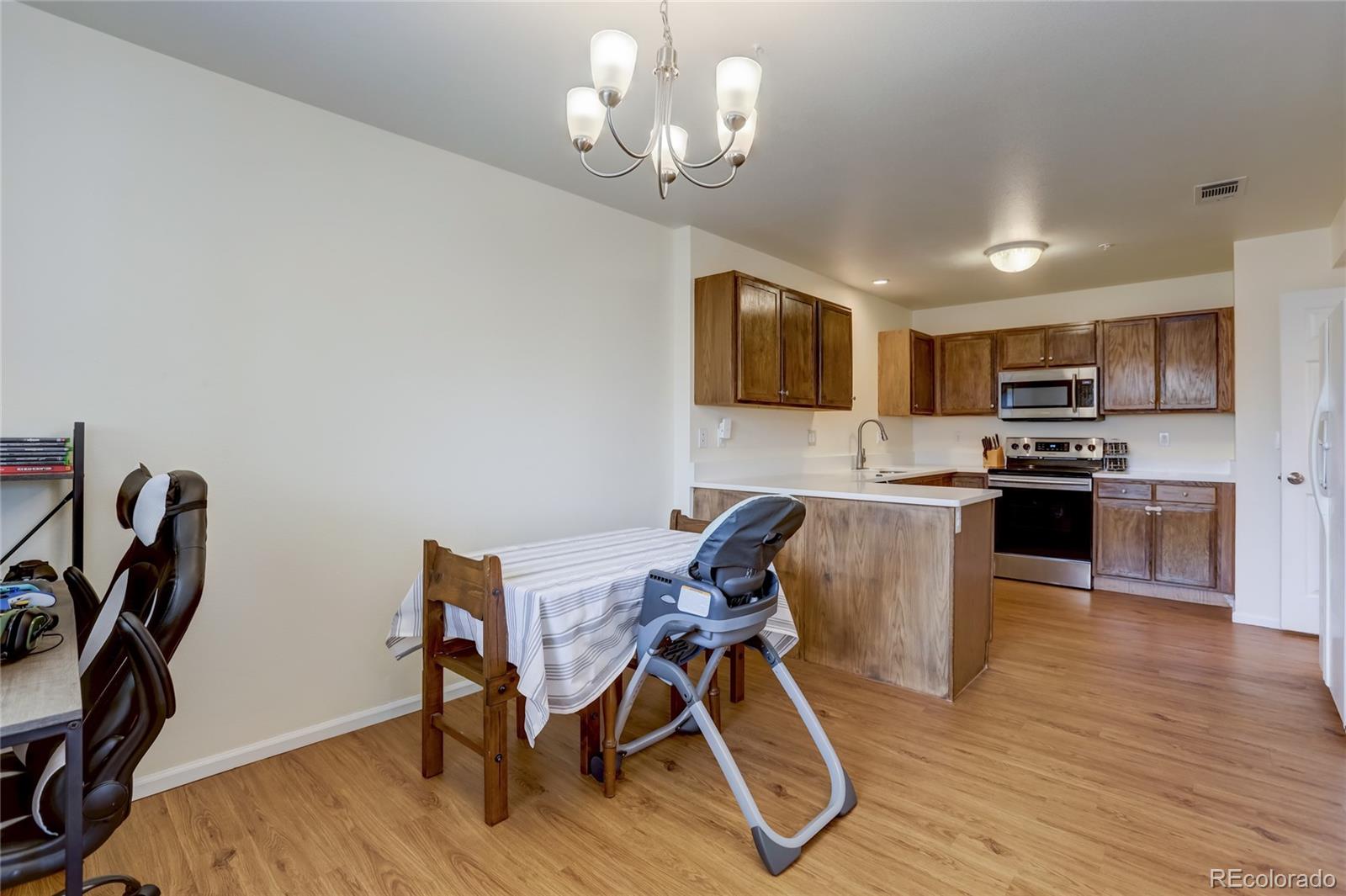 2900 Purcell Street, Unit O4 Brighton, CO 80601 - Photo 12 of 28 a view of a dining room with furniture and wooden floor
