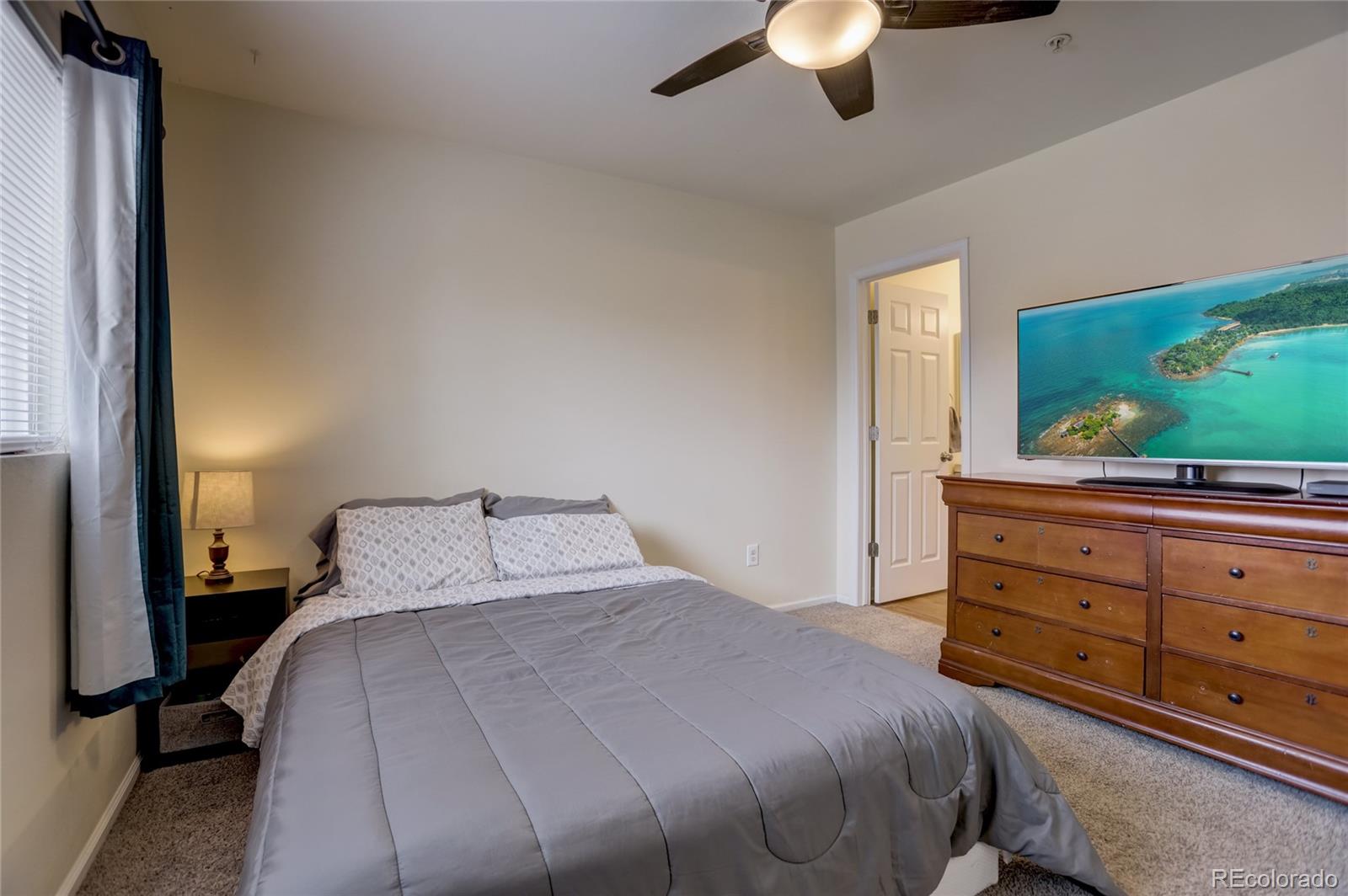 2900 Purcell Street, Unit O4 Brighton, CO 80601 - Photo 16 of 28 a bedroom with a bed and a flat screen tv