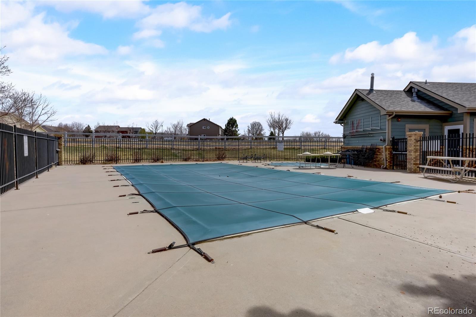 2900 Purcell Street, Unit O4 Brighton, CO 80601 - Photo 25 of 28 a view of swimming pool with outdoor seating and buildings in the background