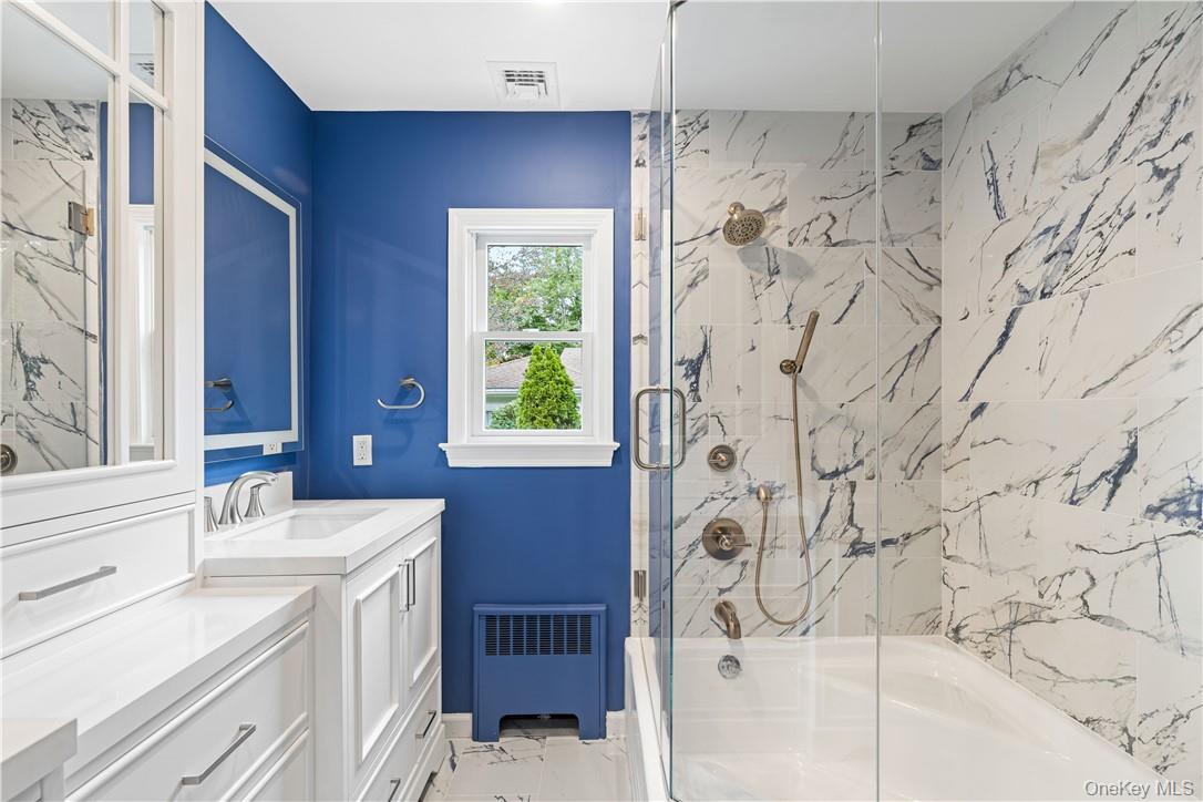 5 Paddock Road Rye Brook, NY 10573 - Photo 14 of 23 Hall bathroom featuring vanity, tub/shower combo with glass door, lighted touch mirrors