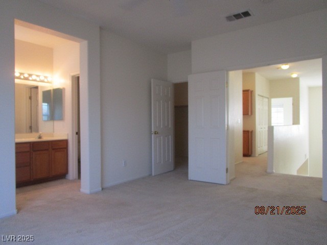 667 Solitude Point Avenue Henderson, NV 89012 - Photo 14 of 22 Unfurnished bedroom featuring light carpet and connected bathroom