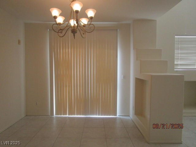 667 Solitude Point Avenue Henderson, NV 89012 - Photo 5 of 22 Unfurnished dining area with light tile patterned floors and a chandelier