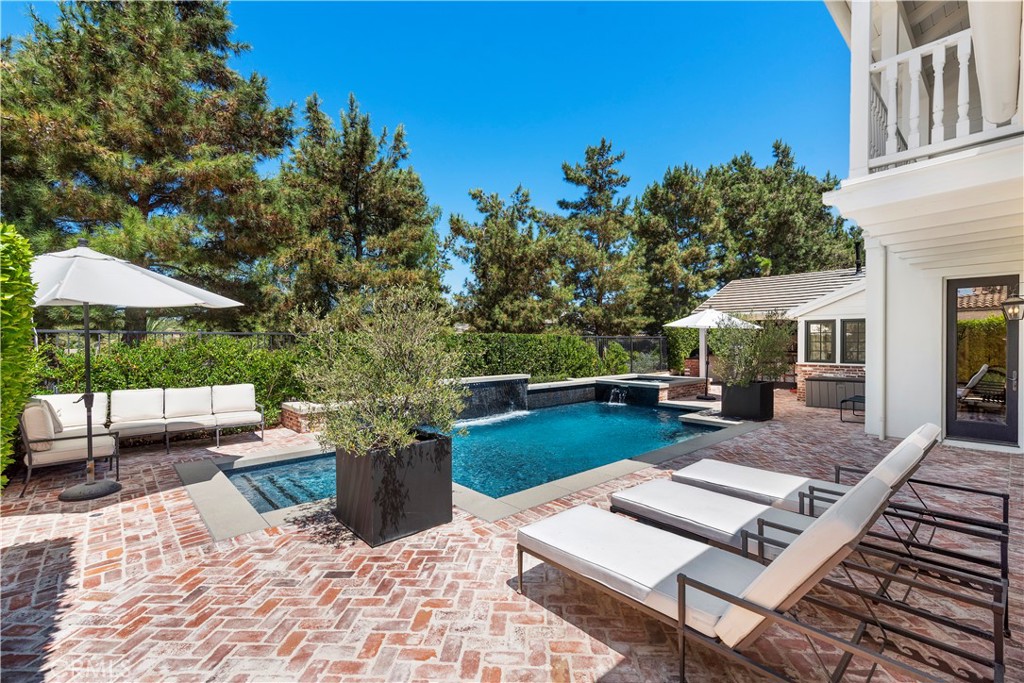5 Connor Court Ladera Ranch, CA 92694 - Photo 7 of 63 a view of a patio with a dining table and chairs under an umbrella with potted plants