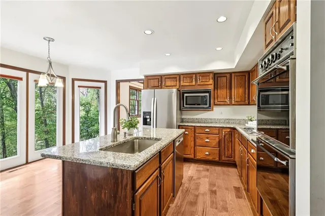 a kitchen with stainless steel appliances granite countertop a sink and stove