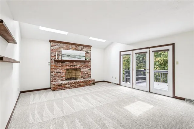 a view of an empty room with a fireplace and a window