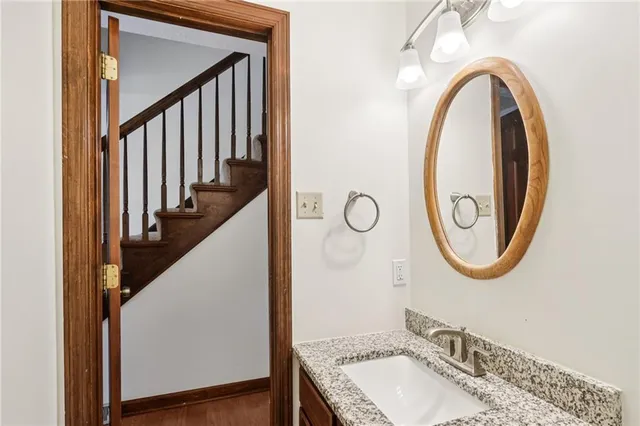 a bathroom with a granite countertop sink and a mirror