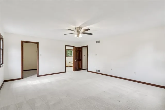 an empty room with fan and windows