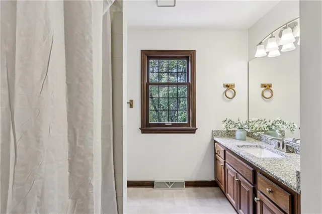 a bathroom with a granite countertop sink and a mirror