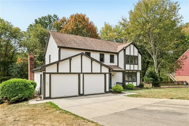 a view of a white house with large windows and a tree