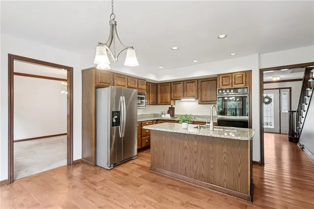 a kitchen with stainless steel appliances granite countertop a refrigerator and a sink