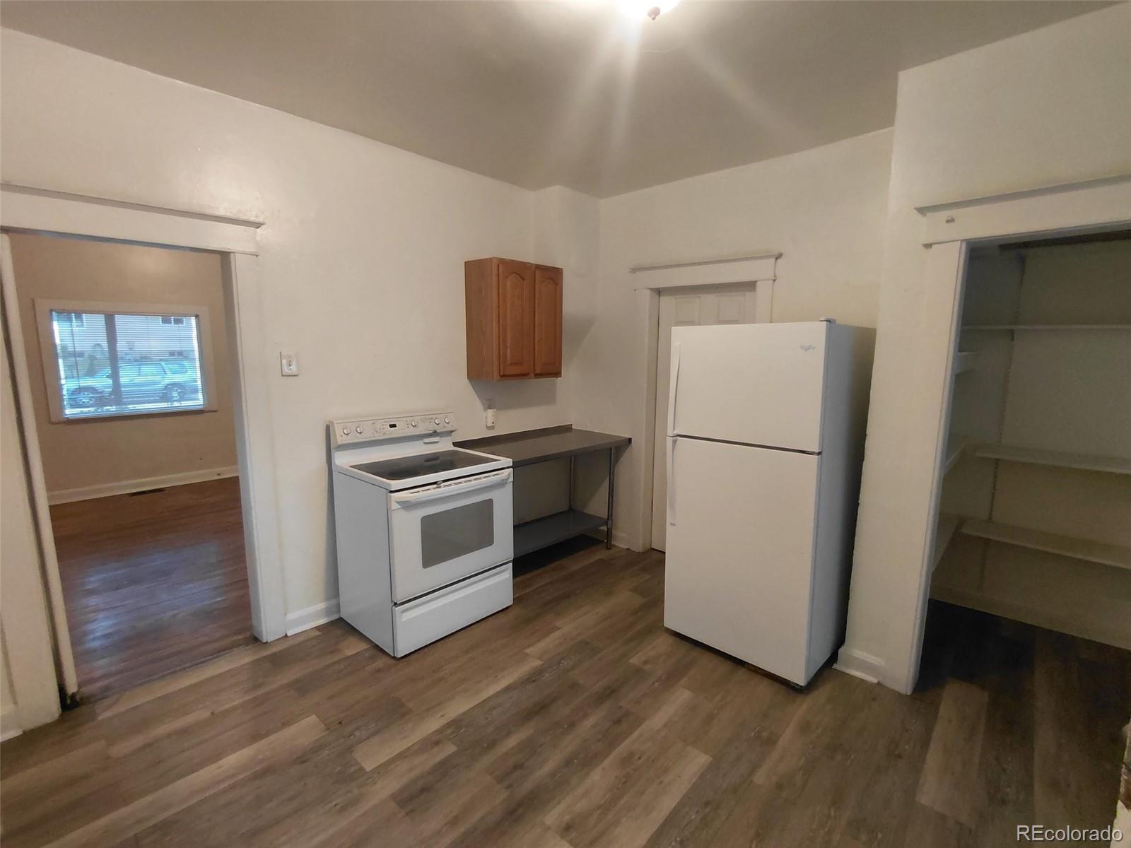 1917 South Fox Street Denver, CO 80223 - Photo 4 of 10 a kitchen with a refrigerator and a stove top oven