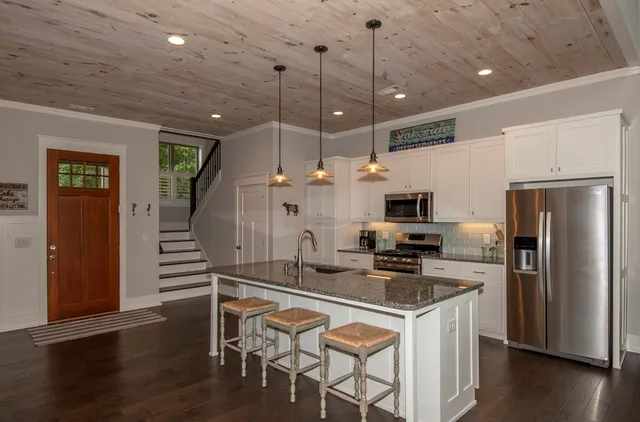 a kitchen with stainless steel appliances granite countertop a sink a oven and a wooden floors