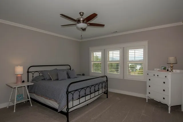 a spacious bedroom with a bed a chandelier and a window
